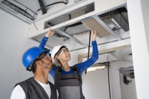 SHK Monteur bei Arbeiten an Klima- und Lüftungstechnik